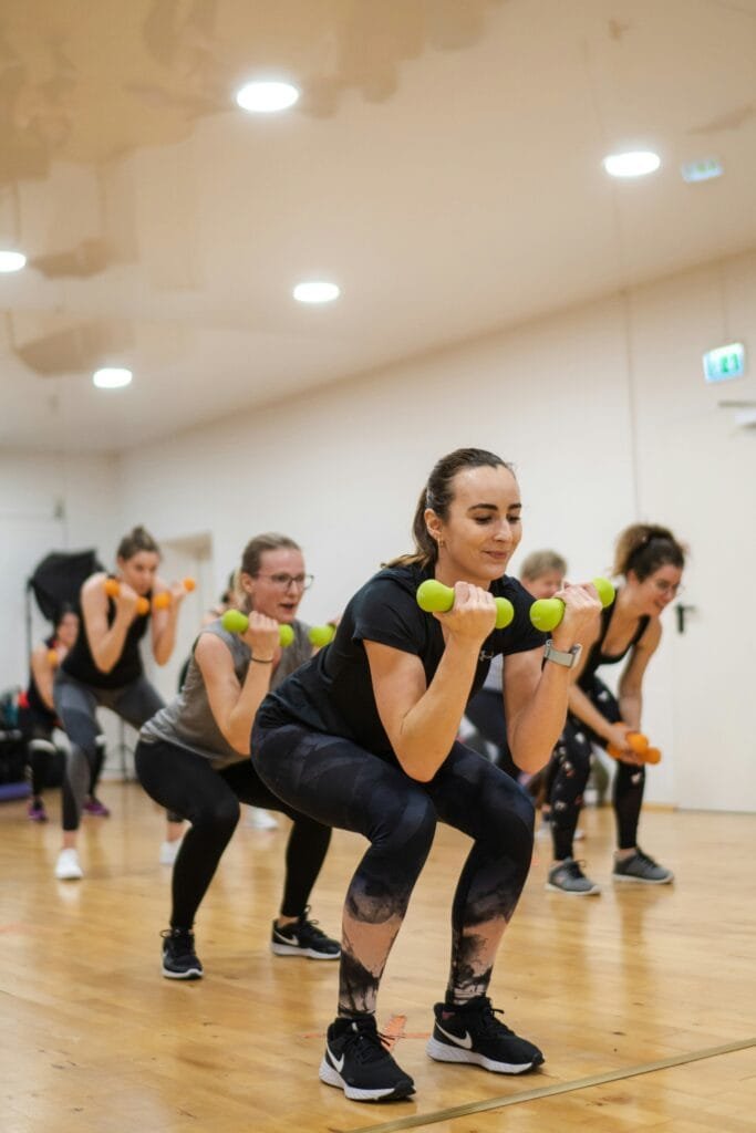 A group of women doing exercises with dumbbells A group of women doing exercises with dumbbells